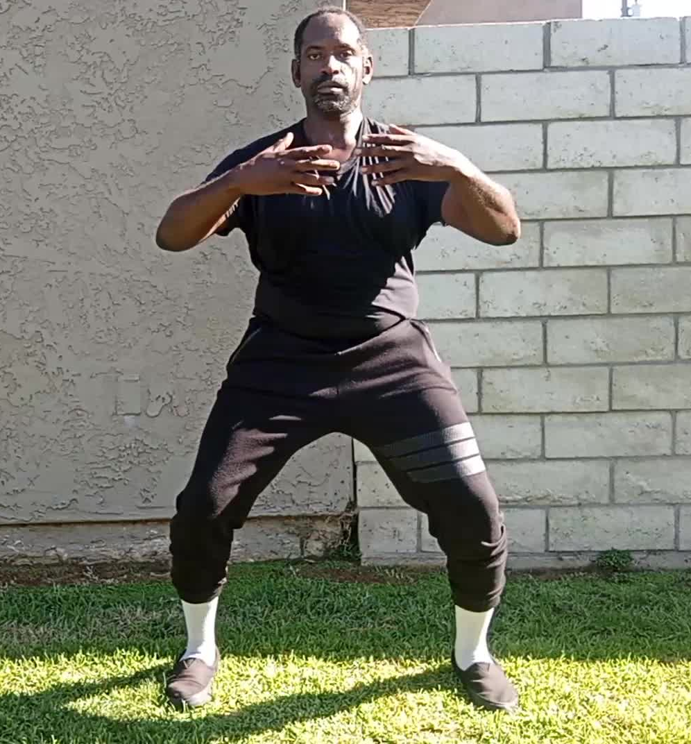 This is a picture of a man standing doing Tai Chi Meditation practice. He offers tai chi online and stress relief courses .