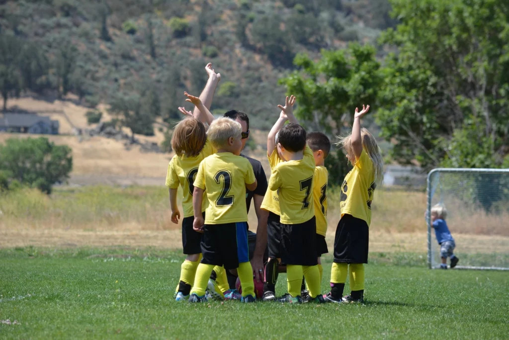 kids into soccer celebrate as a team
